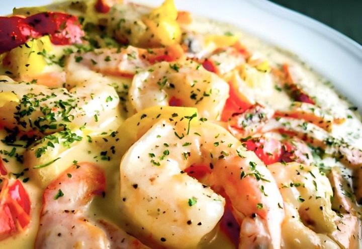 Crevettes tigrées sautées, oignons, poivrons rouges et verts dans une sauce crémeuse.